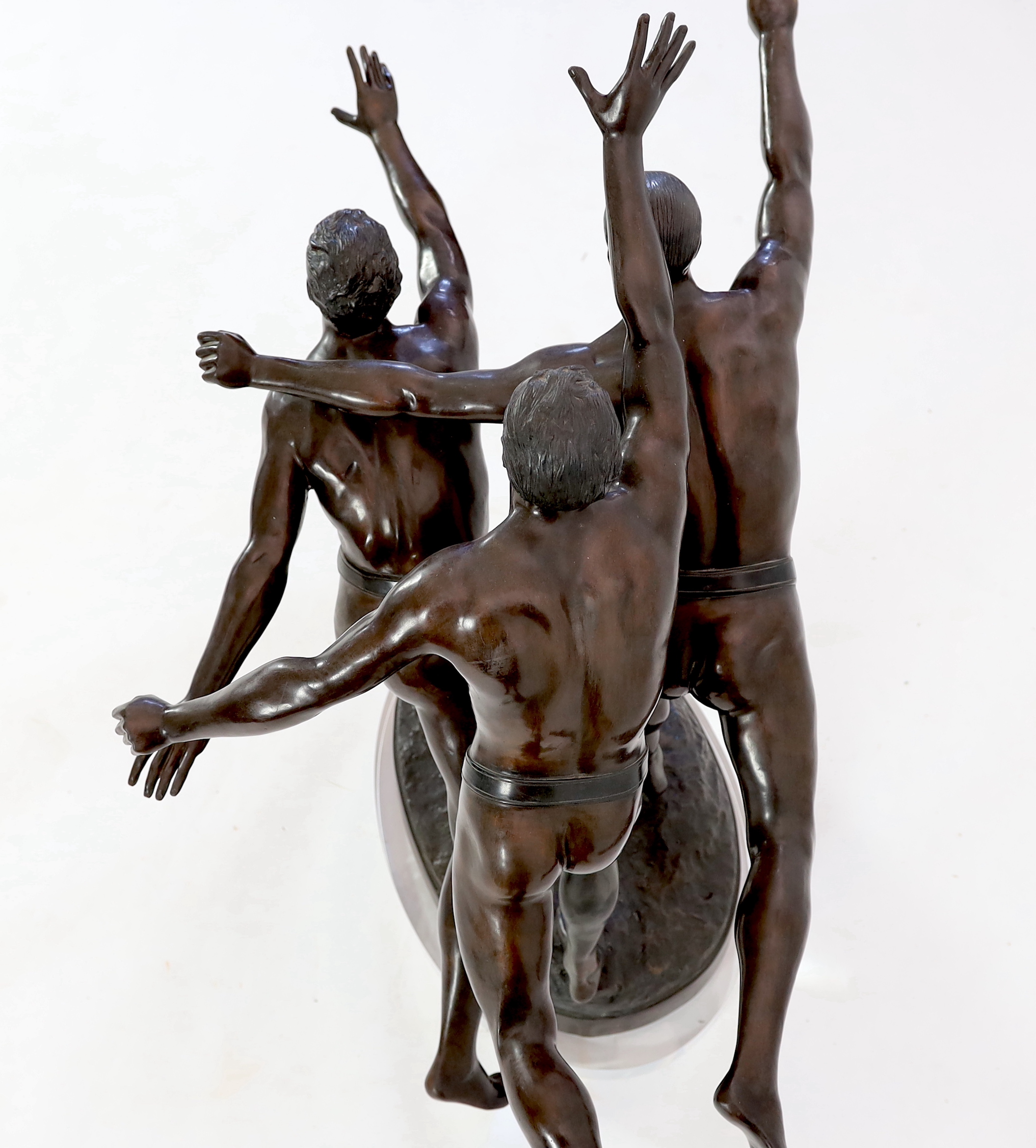 After Alfred Boucher (French, 1850-1934). A large bronze group of three runners at the finishing line, 'Au But', 128cm long, 78cm deep, 111cm high